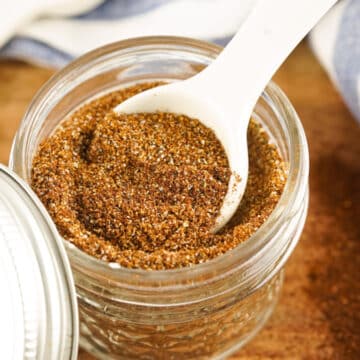 homemade chili seasoning in a mason jar with a measuring spoon