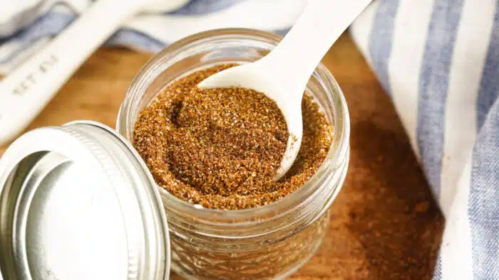 homemade chili seasoning in a mason jar with a measuring spoon
