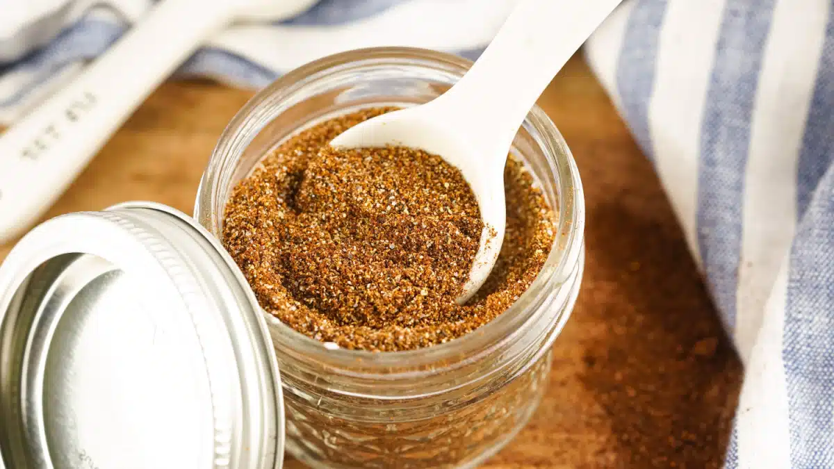 homemade chili seasoning in a mason jar with a measuring spoon