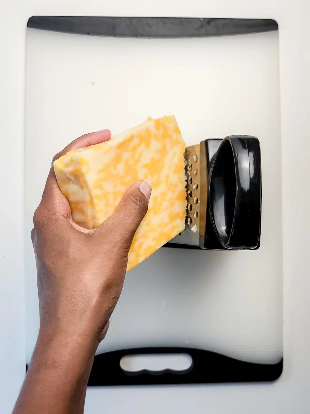 grating cheese by hand with a box grater
