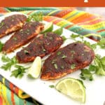 platter of blackened chicken with lime and parsley and text overlay
