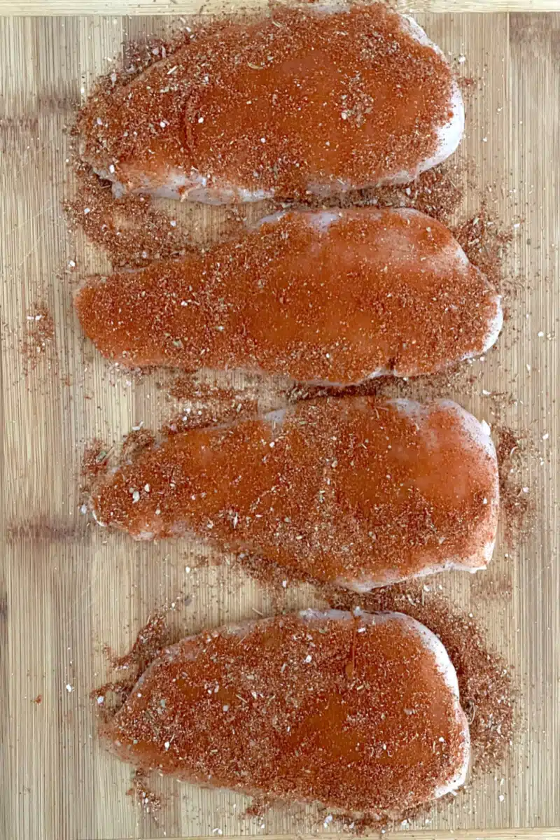 chicken with blackening seasoning on a wooden board