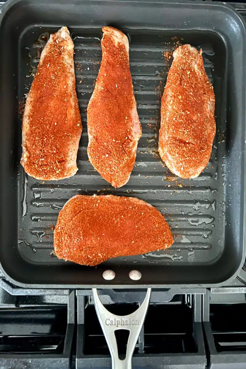 cooking blackened chicken in a grill pan