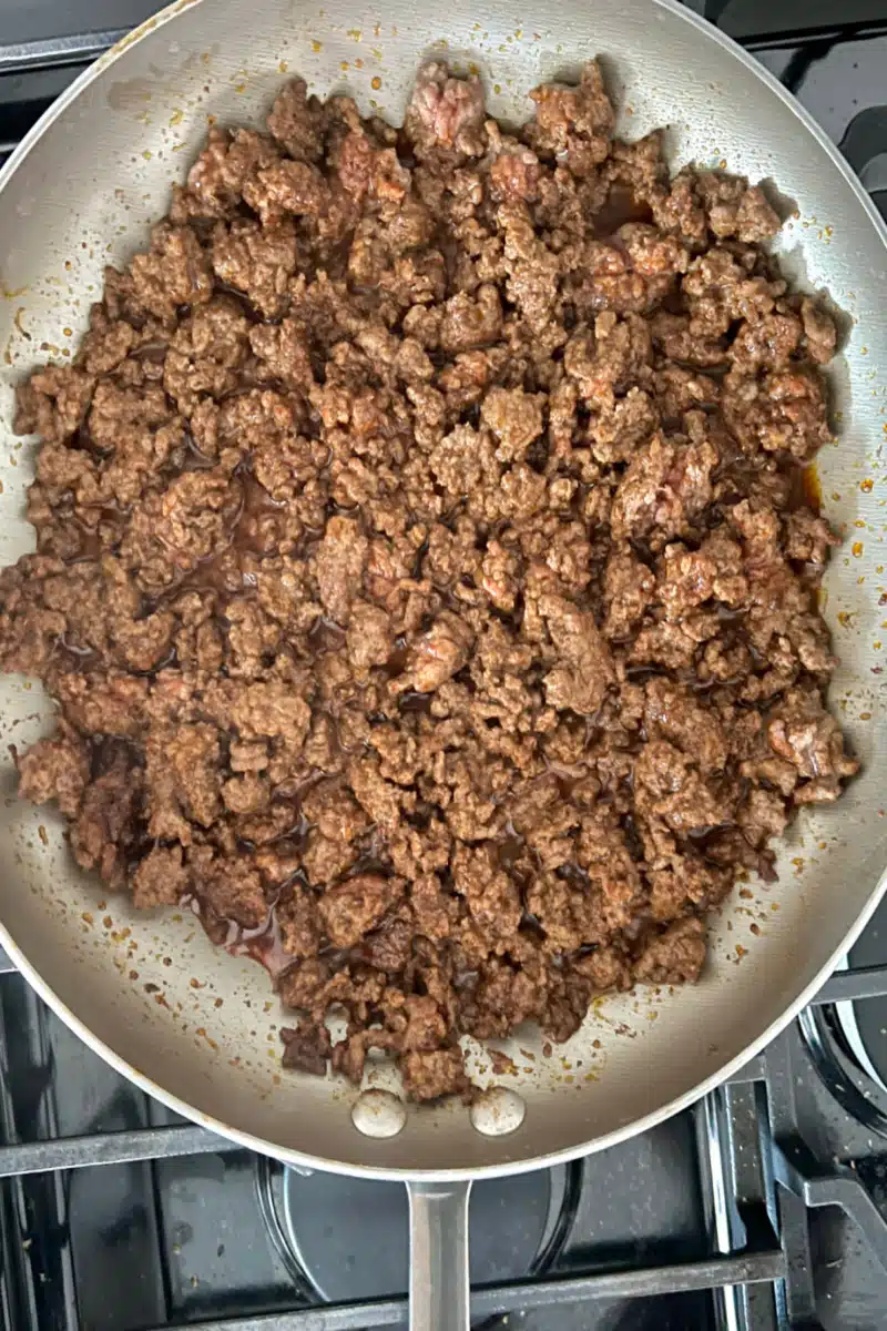 browning ground beef with seasonings in a skillet