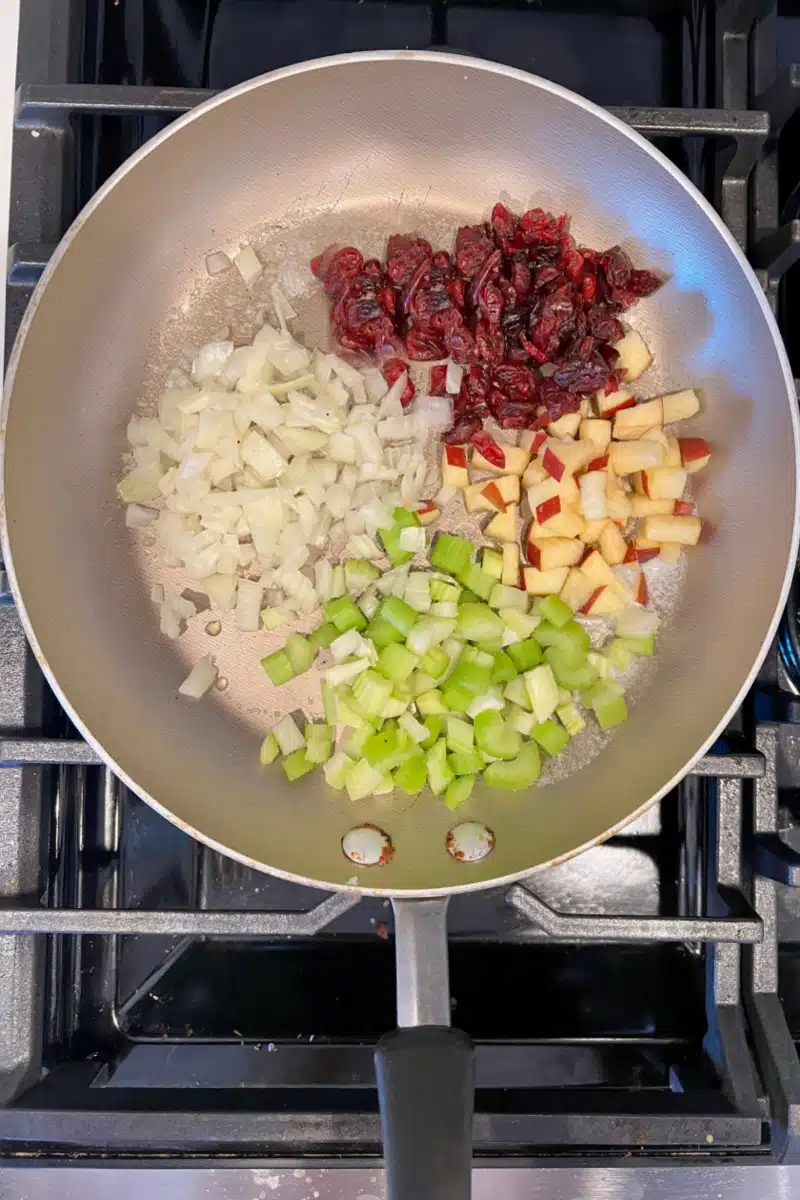 sauteeing celery, onion, apple and dried cranberries in a skillet