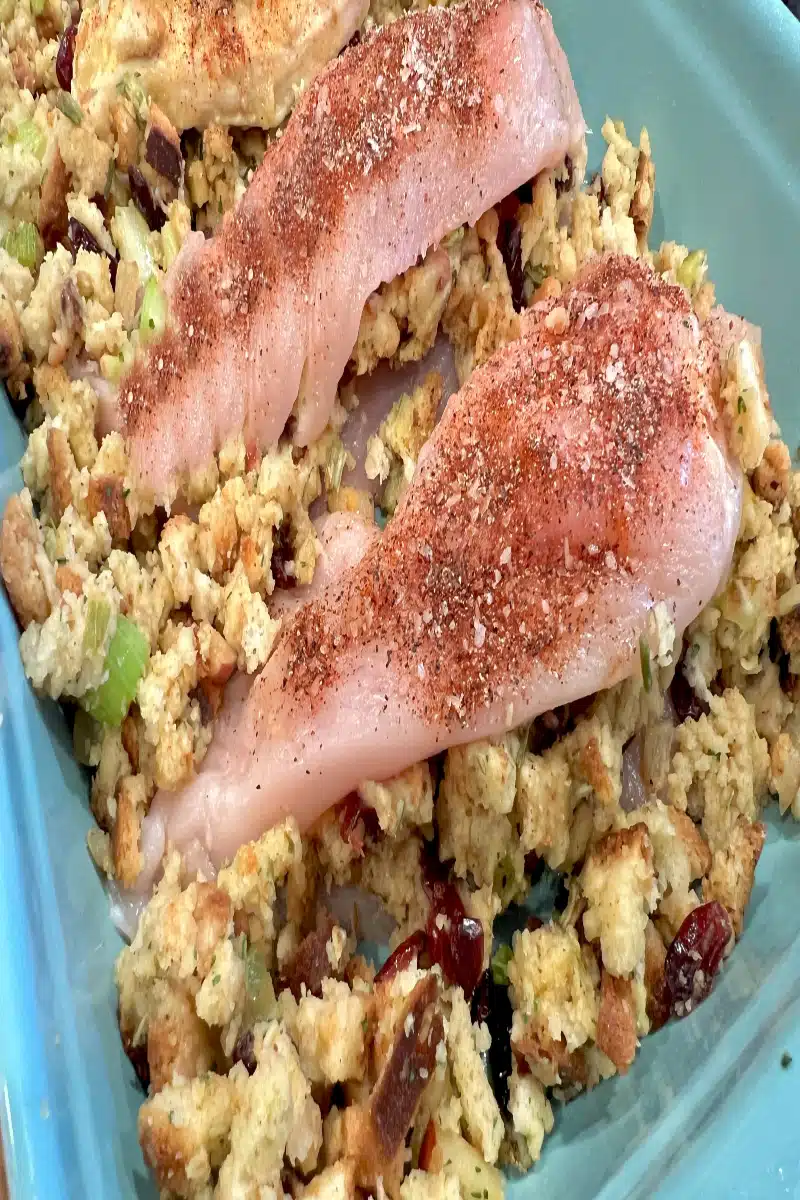 arranging stuffed chicken breasts and stuffing in baking dish