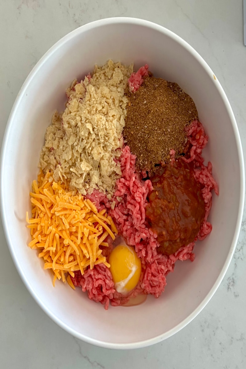 combining ingredients in a bowl for taco meatballs