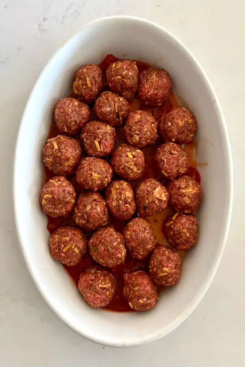 mini meatballs arranged in an oval baking dish