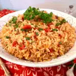 tomato and rice recipe in a serving bowl with fresh parsley garnish