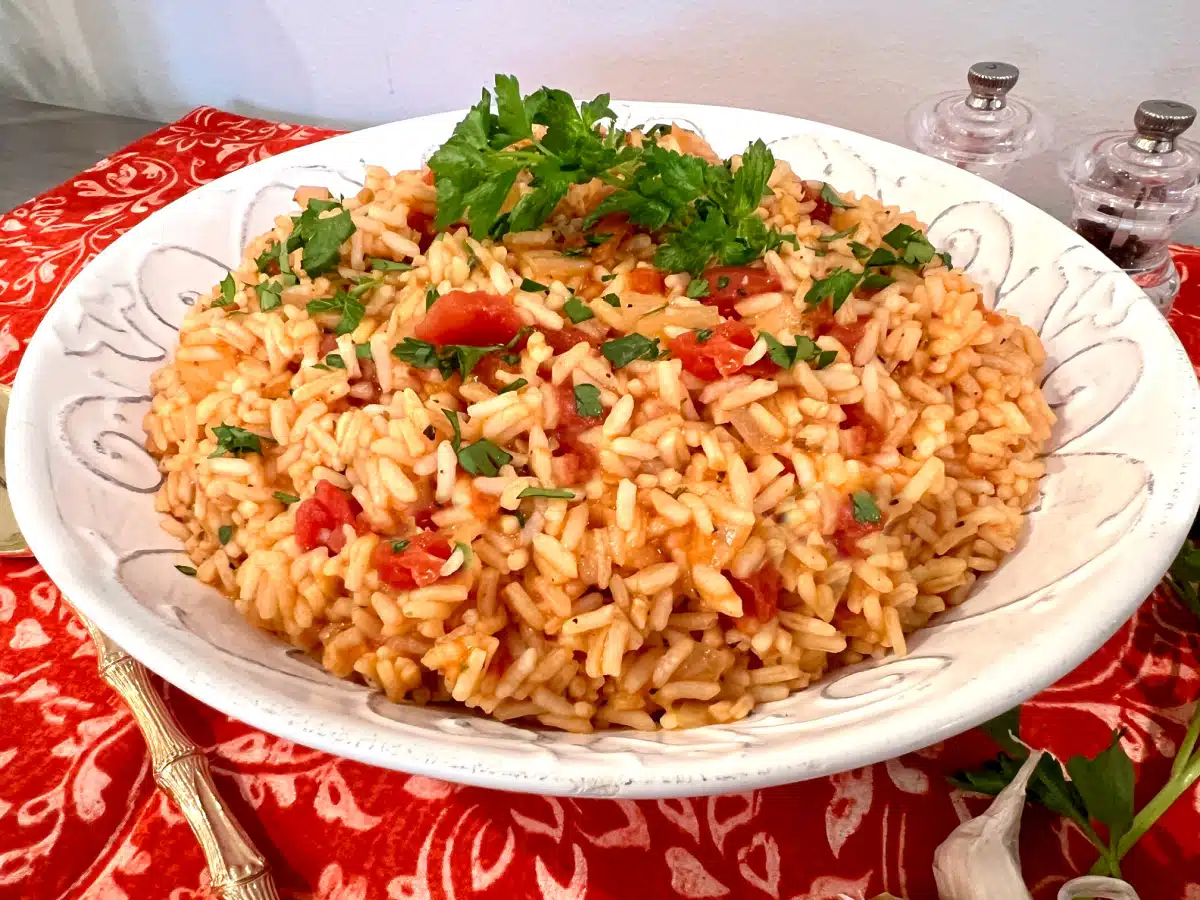 tomato and rice recipe in a serving bowl with fresh parsley garnish