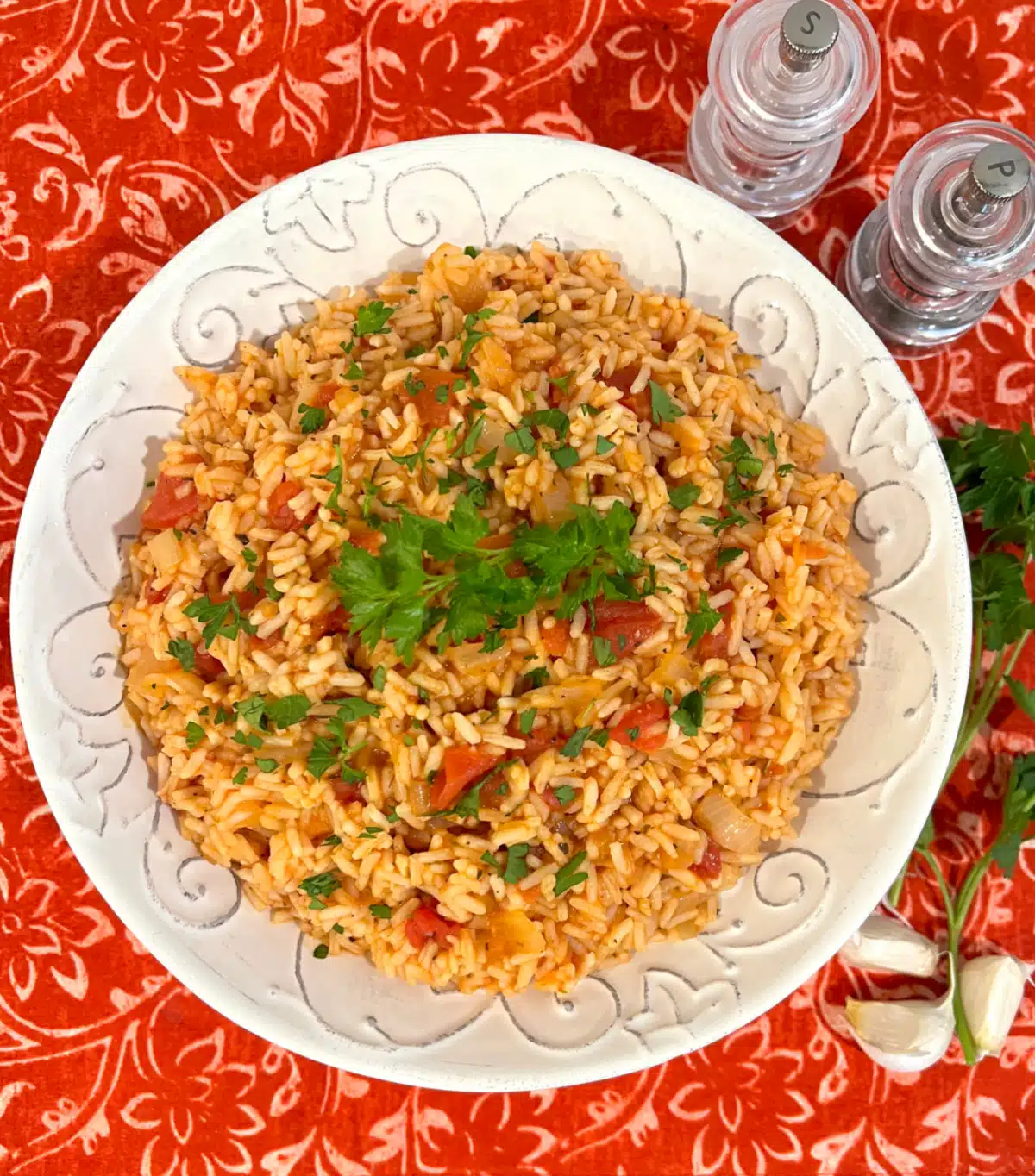 overhead of tomato rice recipe in a round serving dish on a colorful napkin