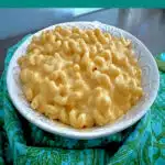 bowl of mac and cheese made with Velveeta on a pretty blue napkin with text overlay