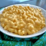 Velveeta mac and cheese in a white serving bowl with blue napkin