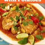 chicken curry on a platter with lime wedges and text overlay