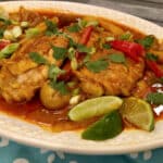 chicken curry with potatoes and peppers on an oval white platter