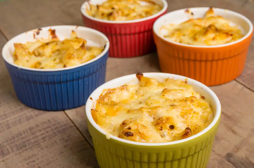 four ramekins filled with mac and cheese