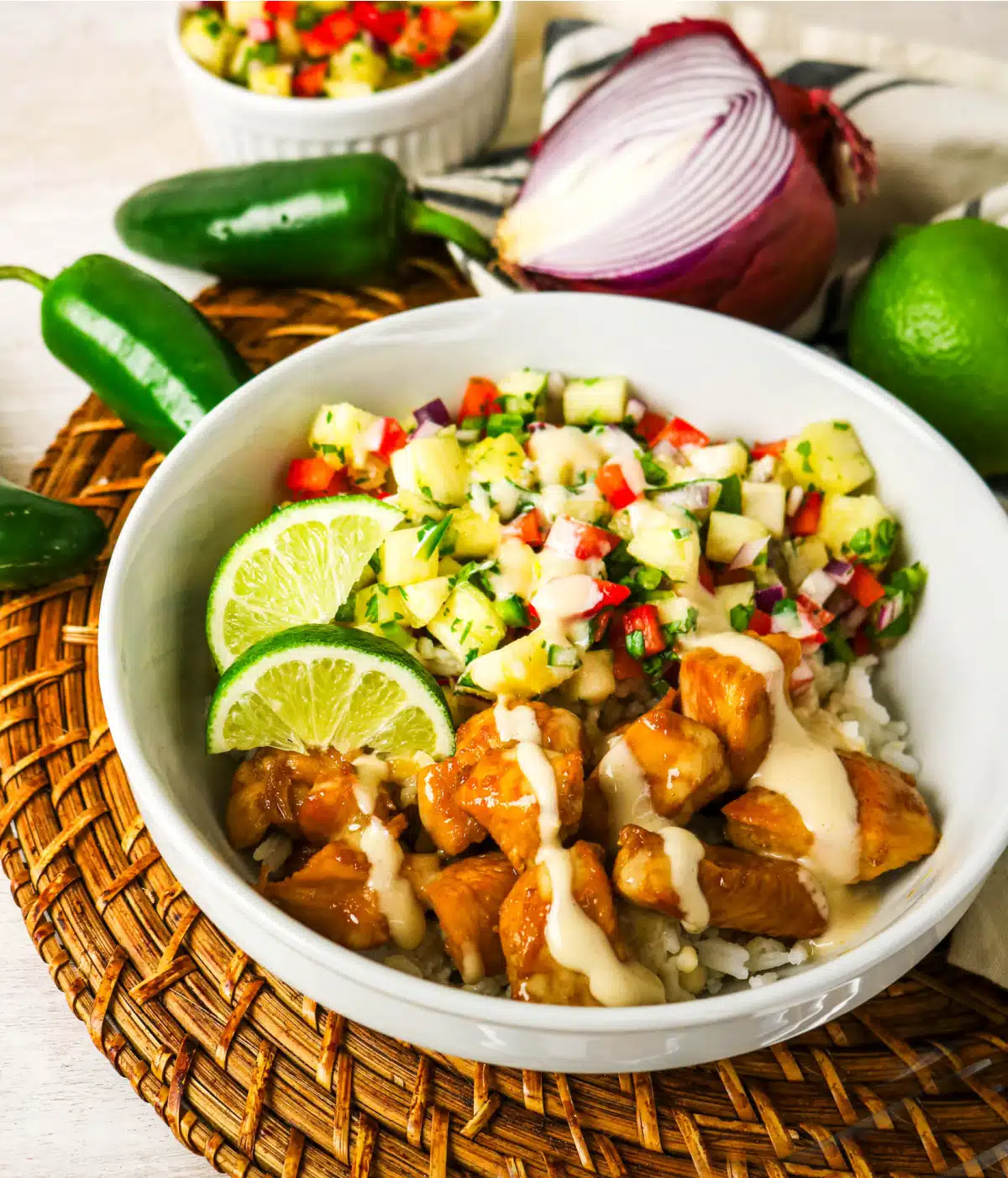 pineapple salsa chicken bowl on a woven placement