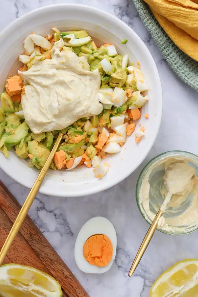stirring Greek yogurt mixture with egg and avocado