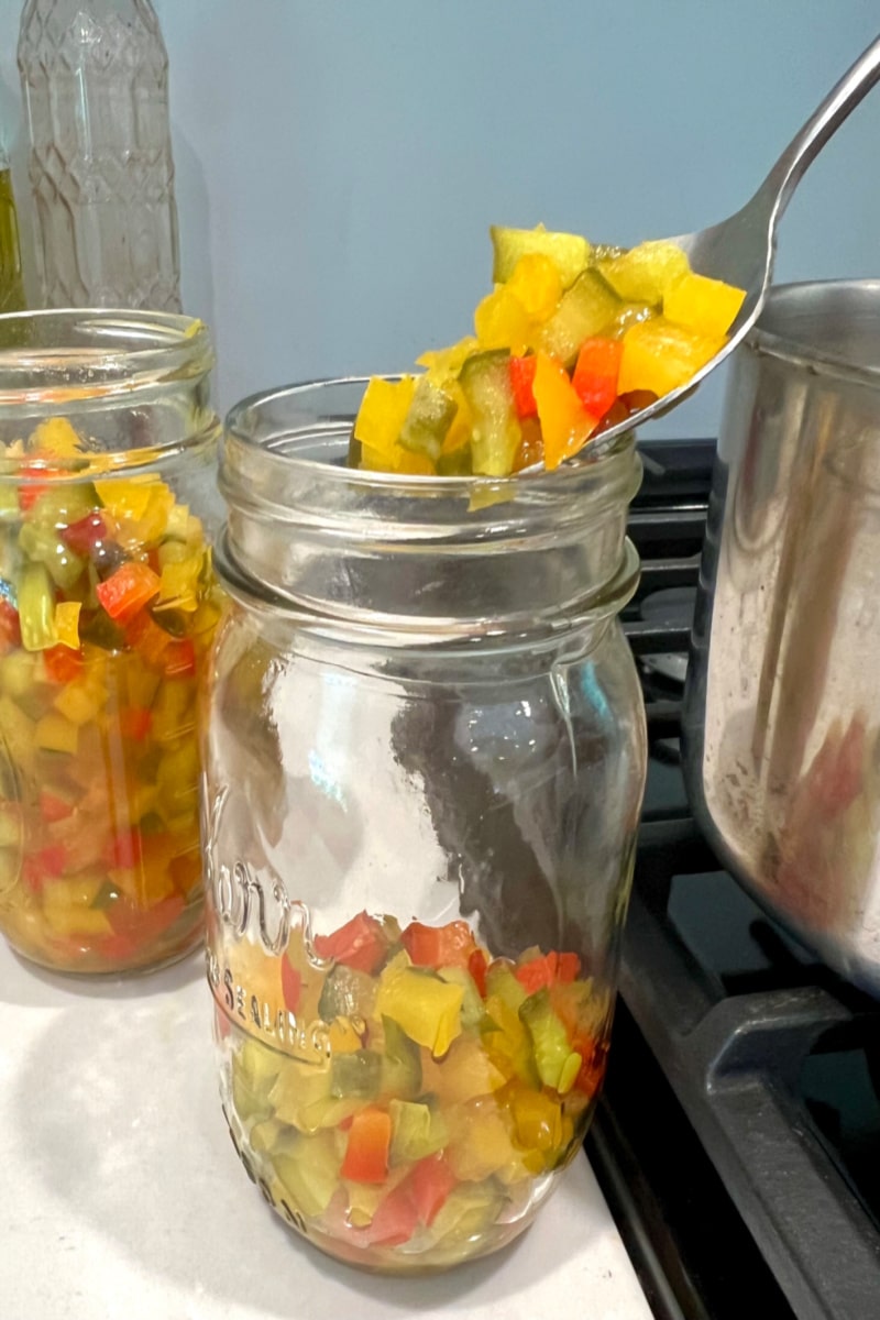 spooning chopped begetables into mason jar