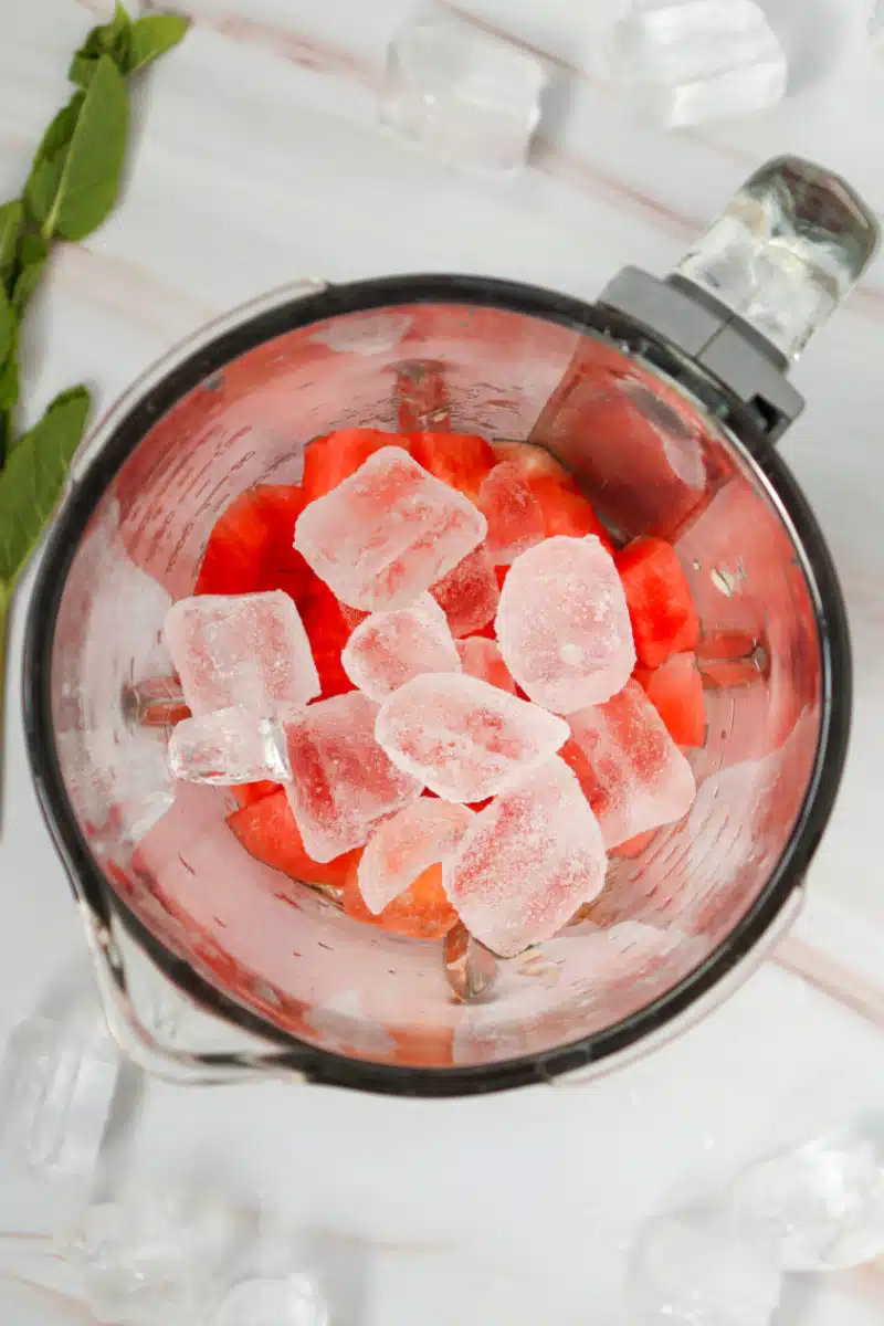 adding ice to watermelon in a blender