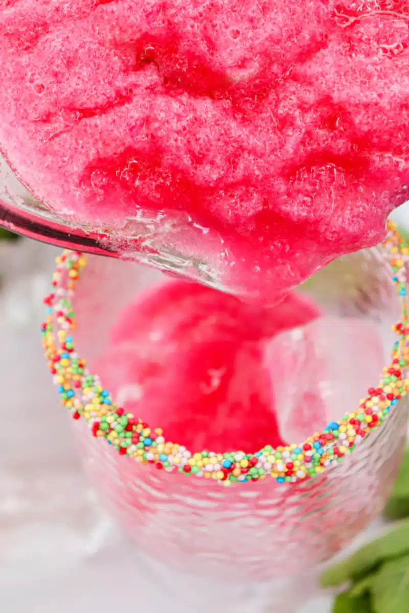 pouring watermelon cocktail into a glass