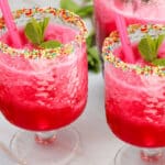 two glasses of watermelon vodka cocktail with sprinkles on rims