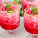 two glasses of watermelon vodka cocktail with sprinkles on rims