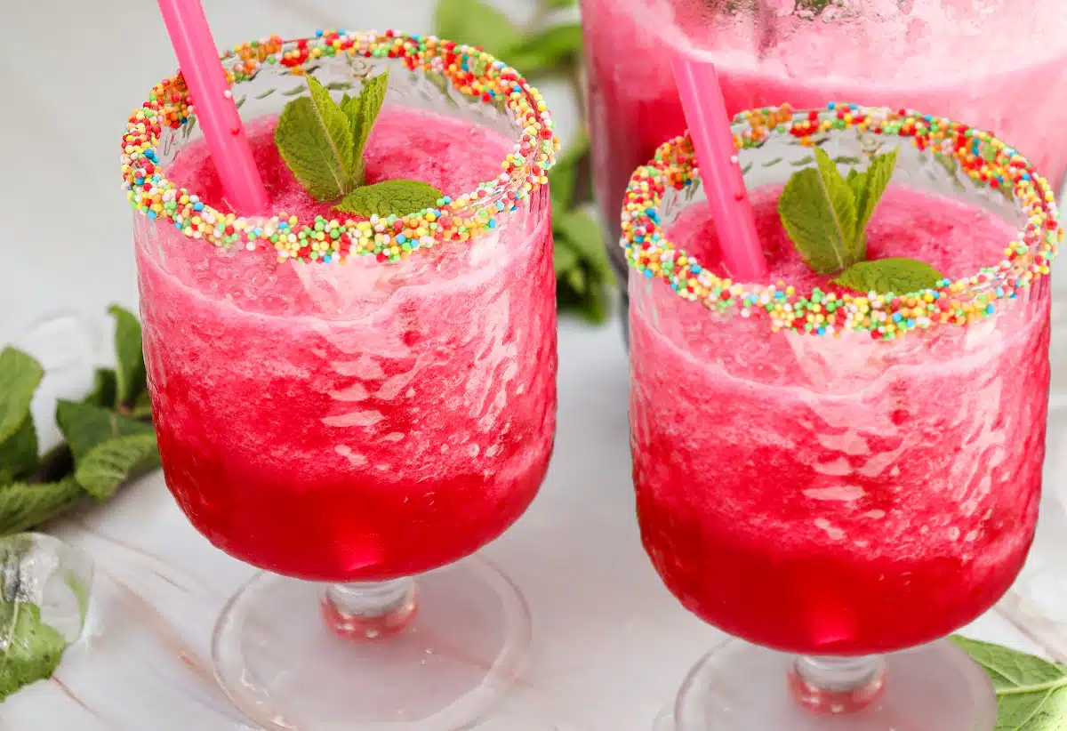 two glasses of watermelon vodka cocktail with sprinkles on rims