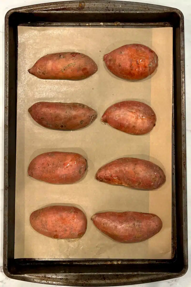cinnamon sugar sweet potato halves arranged on a baking sheet