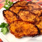 close up of cinnamon sugar sweet potato halves on a white dish