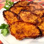 close up of cinnamon sugar sweet potato halves on a white dish