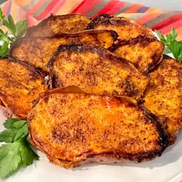 cinnamon sugar sweet potatoes on a round dish with fresh parsley