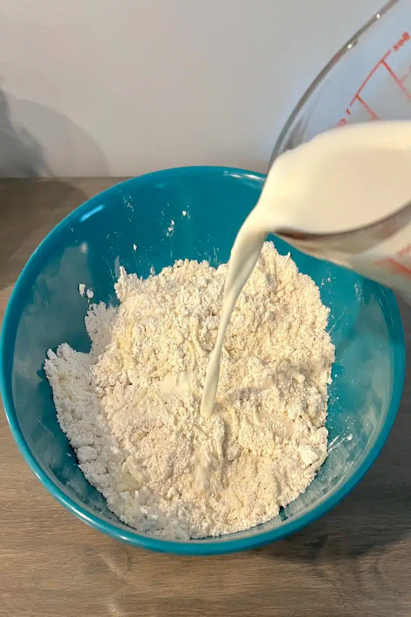 pouring milk into biscuit mix
