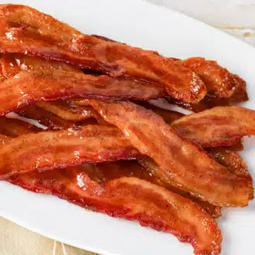 slices of candied bacon on a white plate