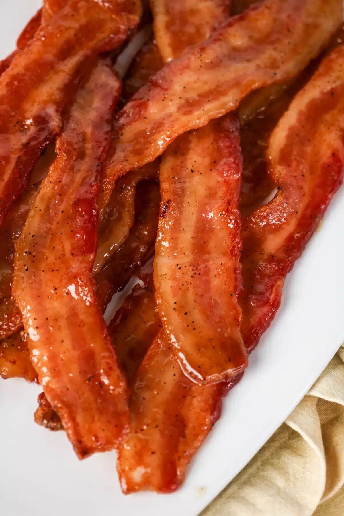 overhead of candied maple bacon on a white dish
