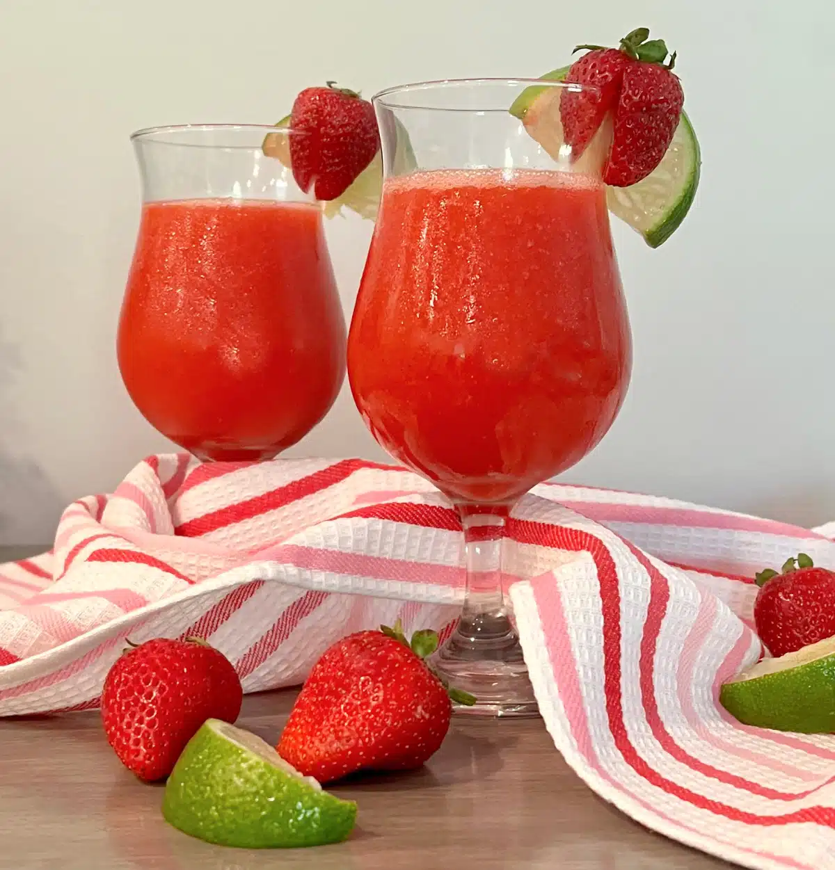 two glasses of strawberry daiquiris with pretty napkin