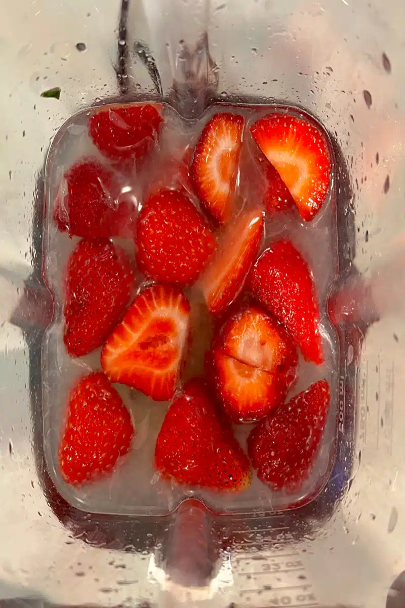 Rum, lime juice, syrup and strawberries in a blender