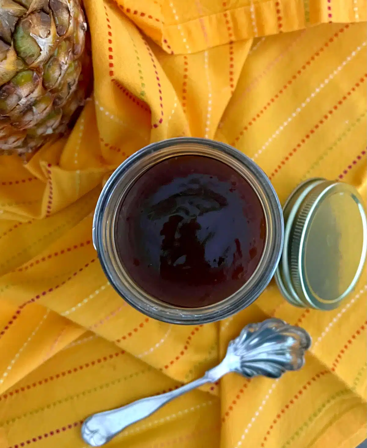 overhead photo of sweet and sour sauce with a pretty spoon and yellow napkin