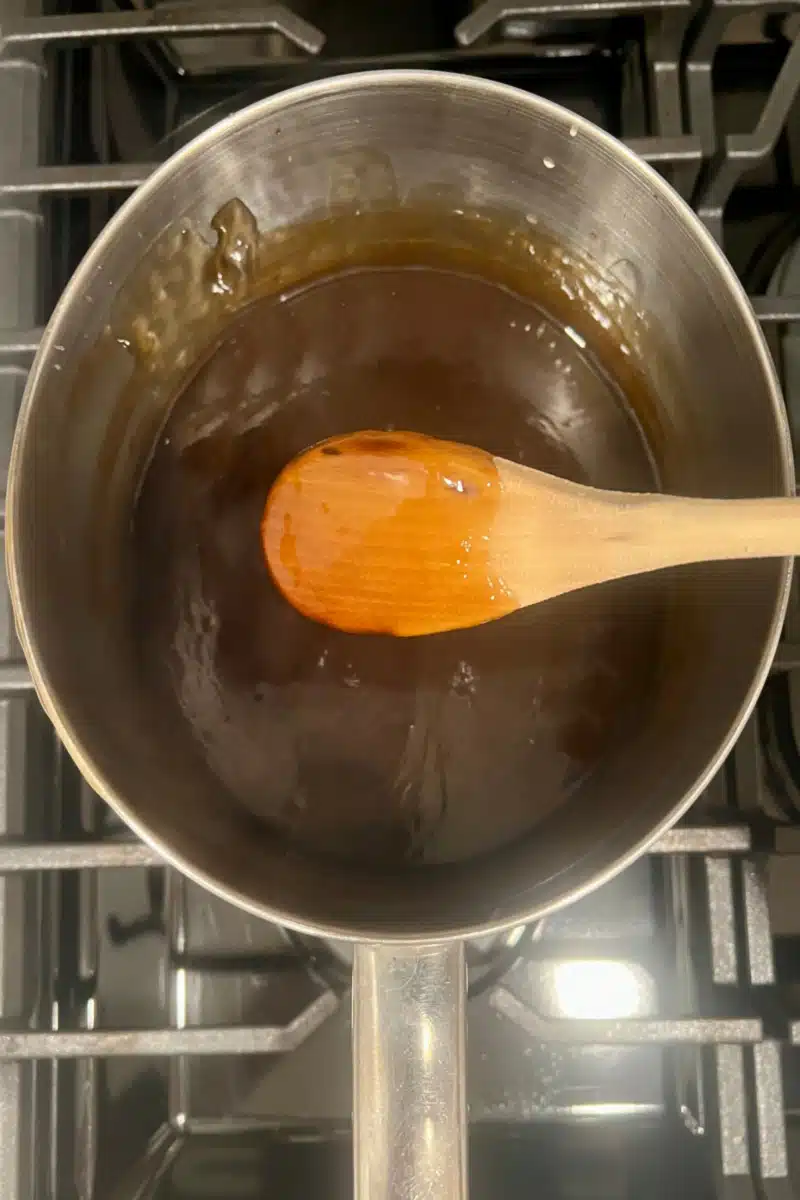 sweet and sour sauce coating the back of a wooden spoon