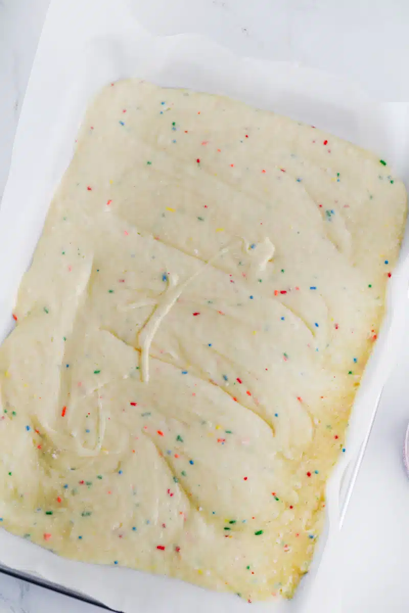cake batter in a baking pan lined with parchment paper