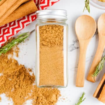 spice jar filled with gingerbread spice and wooden spoons, cinnamon stick and pretty napkin