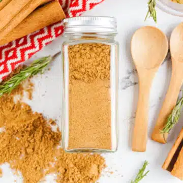 spice jar filled with gingerbread spice and wooden spoons, cinnamon stick and pretty napkin