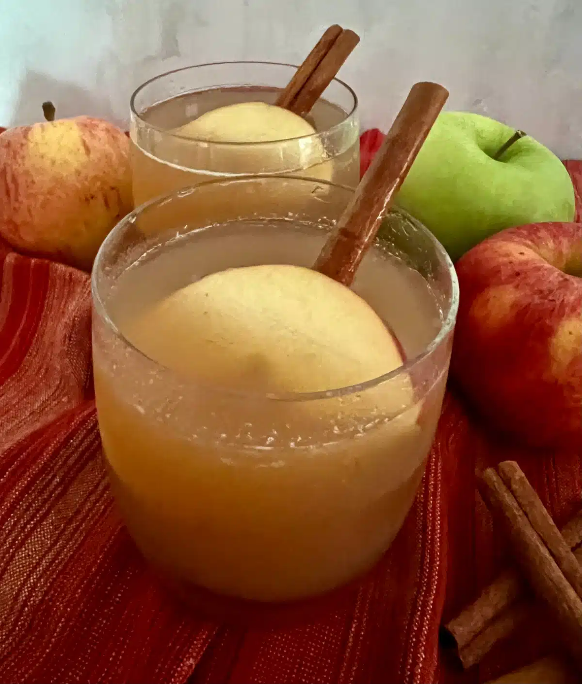 homemade apple cider in a glas with apple slice and cinnamon stick