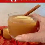 holding a glass of apple cider with text overlay